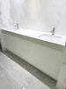 Modern bathroom vanity with white countertop and marble wall. Custom project 90 inches. Pinecrest, Florida.