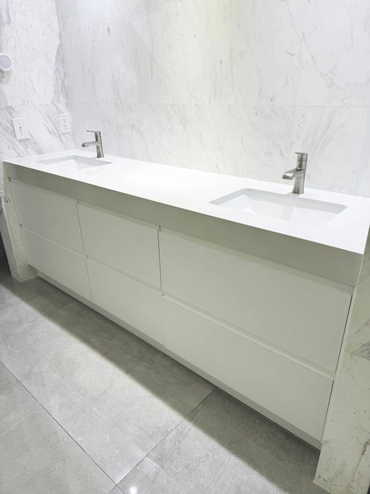 Modern bathroom vanity with white countertop and marble wall. Custom project 90 inches. Pinecrest, Florida.